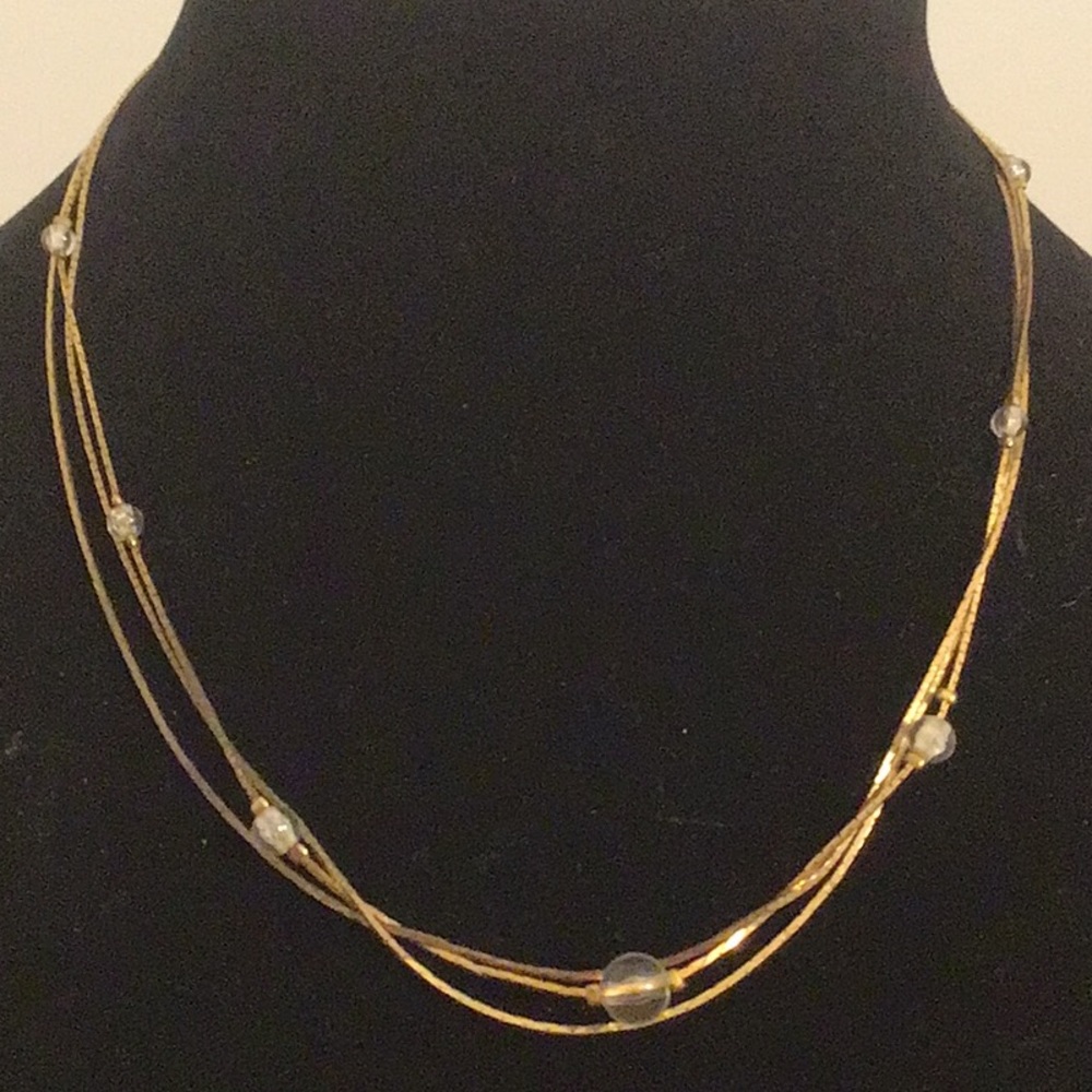 Gold tone three strand necklace with clear beads